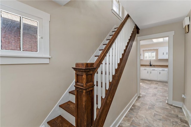 stairs featuring baseboards and stone finish floor