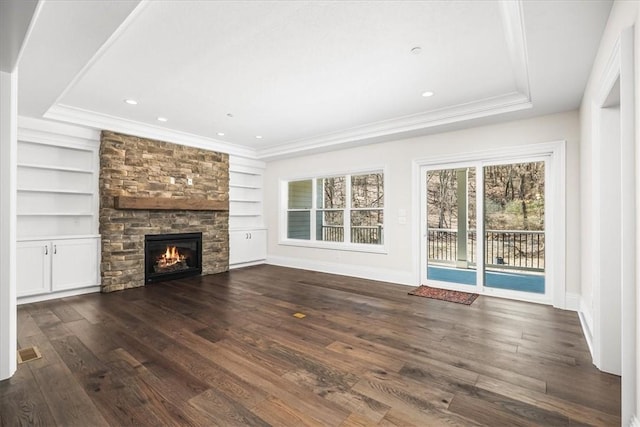 unfurnished living room featuring dark wood finished floors, built in features, crown molding, and baseboards