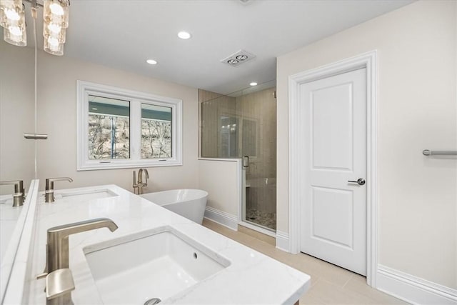 bathroom featuring recessed lighting, baseboards, a stall shower, and a sink