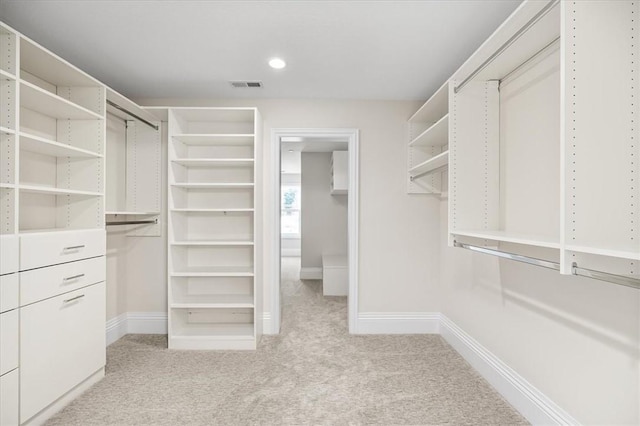 spacious closet featuring light colored carpet and visible vents