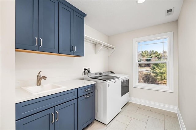 clothes washing area featuring baseboards, visible vents, cabinet space, a sink, and washing machine and dryer