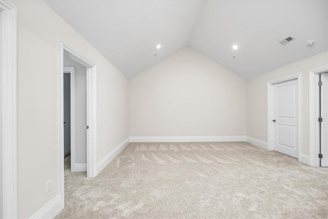 empty room featuring visible vents, light carpet, lofted ceiling, recessed lighting, and baseboards