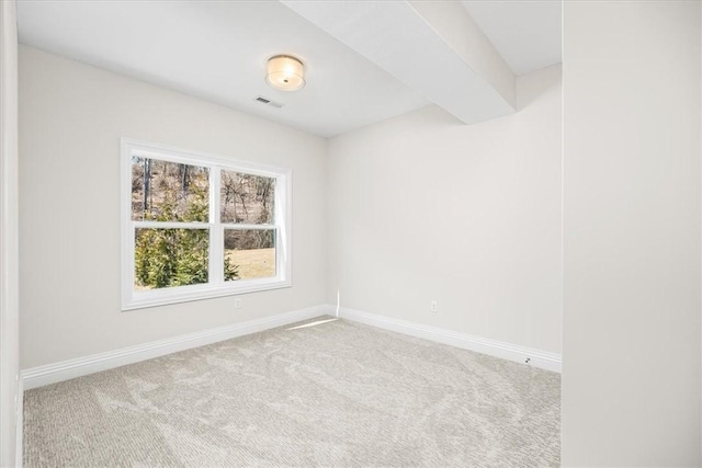 carpeted spare room featuring visible vents, baseboards, and beam ceiling