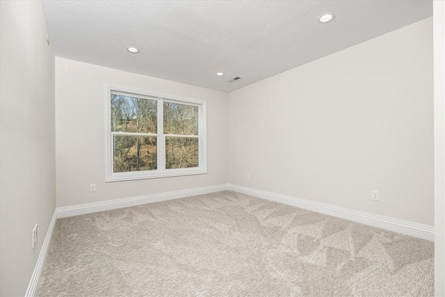 spare room with recessed lighting, baseboards, a textured ceiling, and carpet flooring