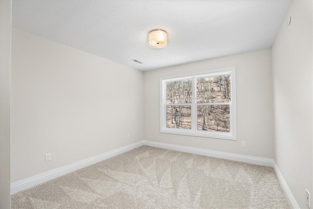 carpeted empty room with visible vents and baseboards