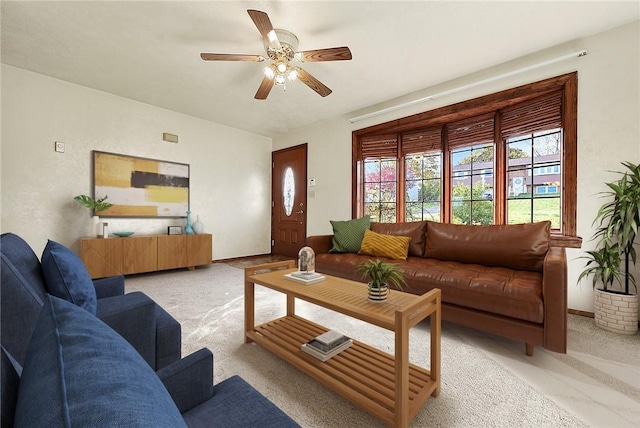 living area with baseboards, carpet, and ceiling fan