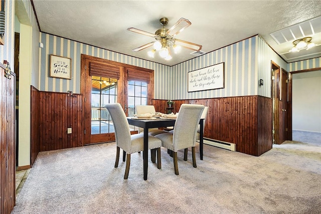 carpeted dining space featuring visible vents, wainscoting, and wallpapered walls