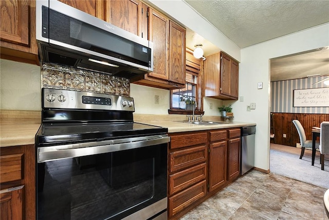 kitchen featuring a textured ceiling, light countertops, appliances with stainless steel finishes, and a sink