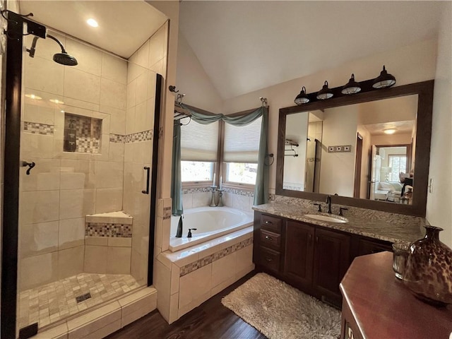 bathroom with a shower stall, a bath, wood finished floors, and lofted ceiling