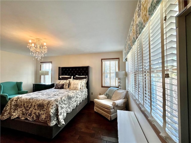 bedroom featuring an inviting chandelier and wood finished floors