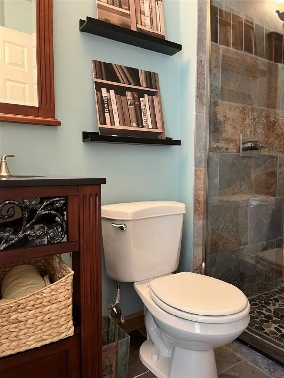 bathroom featuring tile patterned floors, a shower stall, and toilet