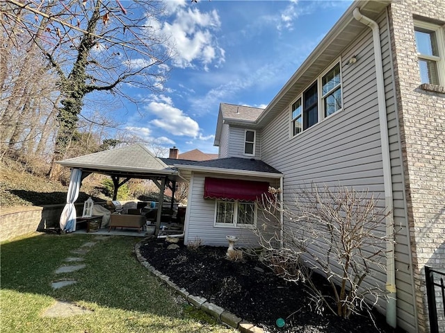 view of side of home with an outdoor living space, a patio area, and a lawn