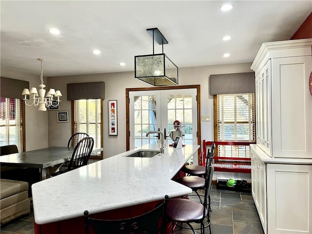 kitchen featuring a chandelier, recessed lighting, a large island with sink, and a sink