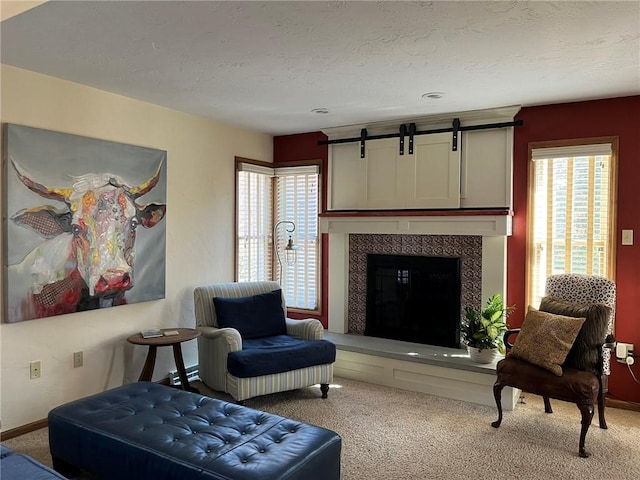 carpeted living area with a tiled fireplace and a textured ceiling