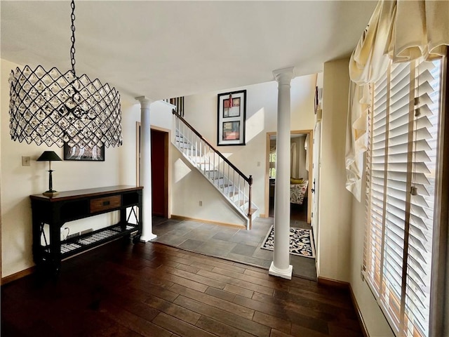 foyer featuring stairway, wood-type flooring, baseboards, and ornate columns