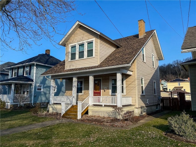 bungalow with a front lawn, fence, covered porch, a shingled roof, and a chimney