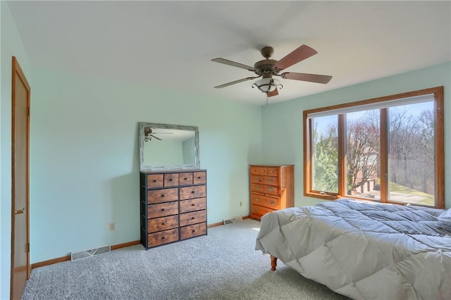 carpeted bedroom with visible vents, a ceiling fan, and baseboards