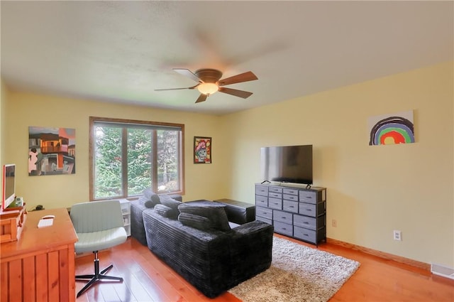 office with a ceiling fan, light wood-style floors, and baseboards