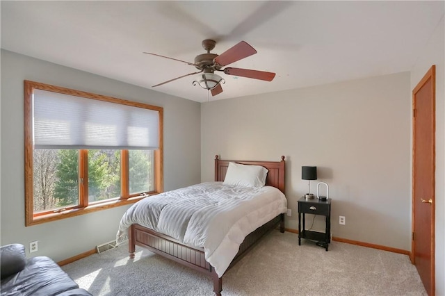 bedroom with ceiling fan, light colored carpet, visible vents, and baseboards