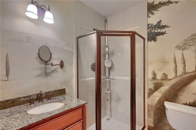 full bathroom featuring vanity, a shower stall, and toilet