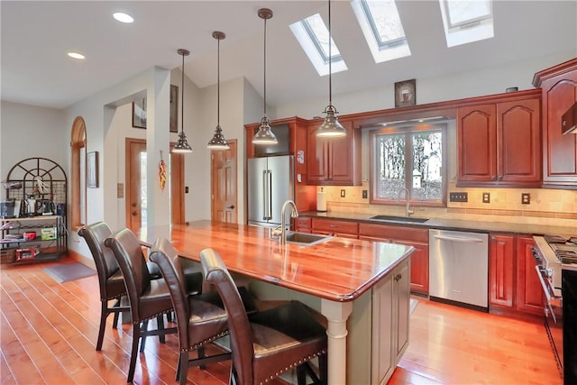 kitchen featuring premium appliances, light wood-style flooring, and a sink