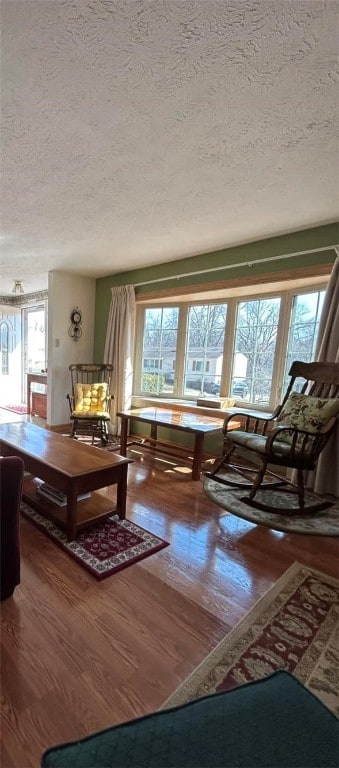 living room featuring a healthy amount of sunlight, a textured ceiling, and wood finished floors