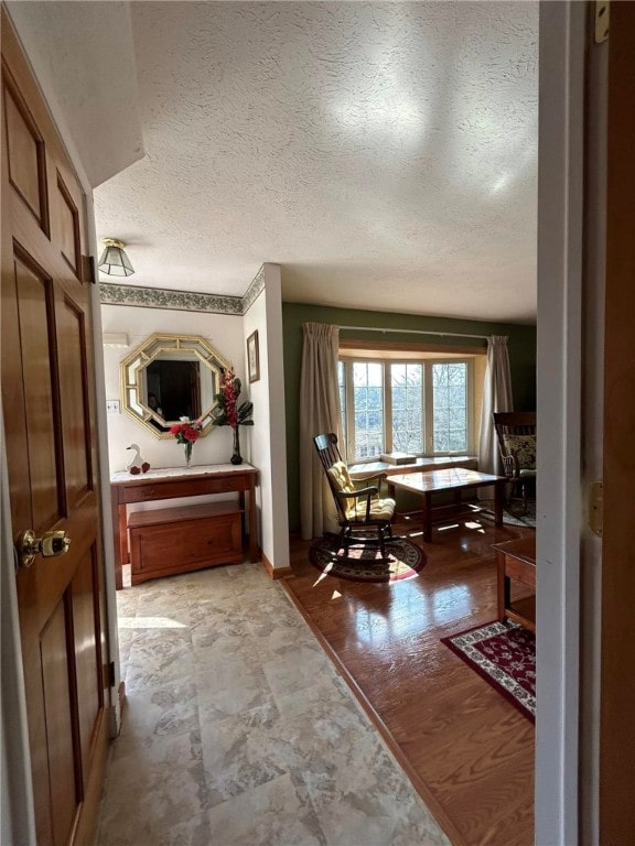 interior space featuring a textured ceiling and baseboards