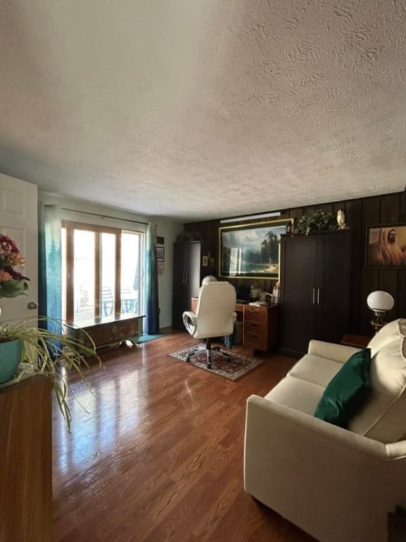 living area with a textured ceiling and wood finished floors