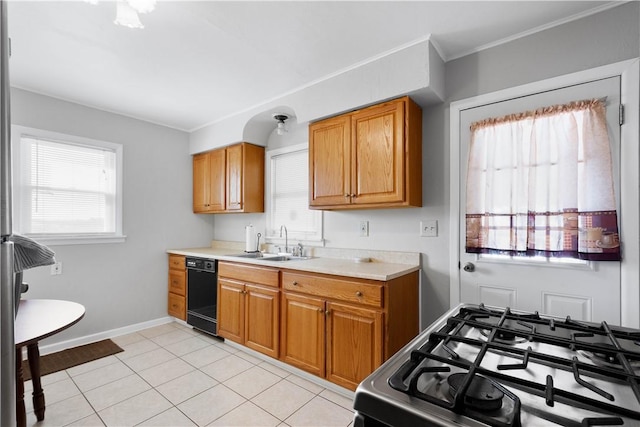 kitchen featuring gas range, light countertops, black dishwasher, light tile patterned flooring, and a sink