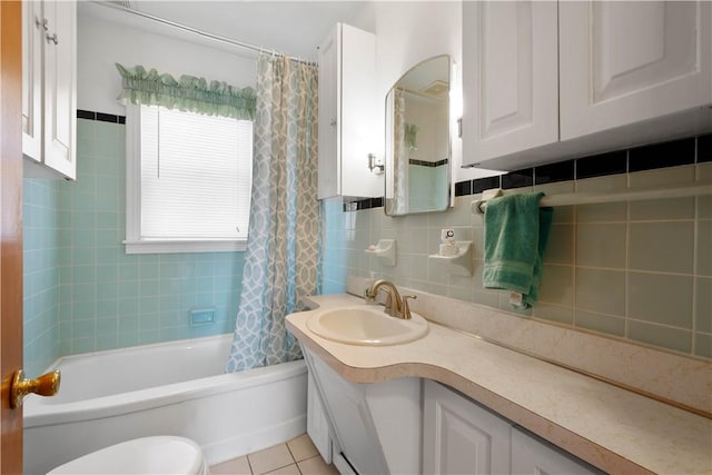 bathroom with vanity, tile patterned flooring, shower / bath combination with curtain, tile walls, and toilet