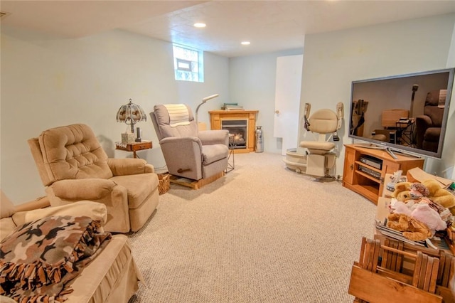 carpeted living room featuring recessed lighting, visible vents, and a warm lit fireplace