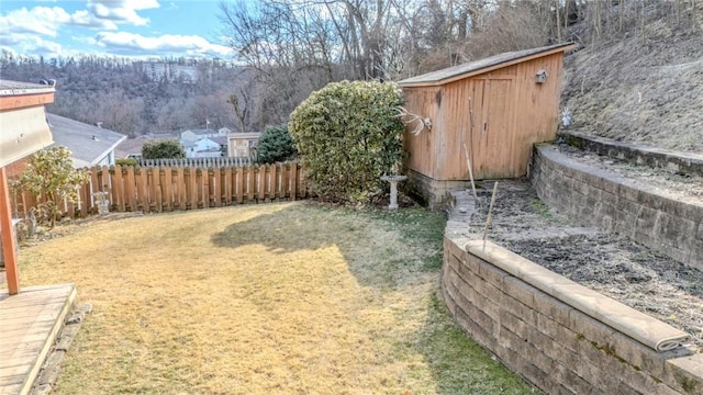 view of yard featuring a storage shed, an outbuilding, and fence