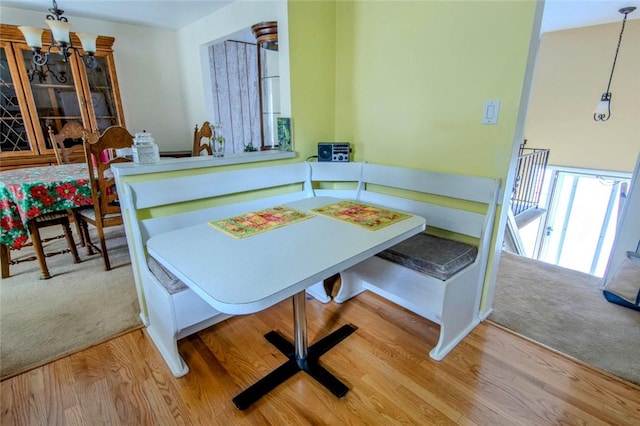 carpeted dining space featuring an inviting chandelier and wood finished floors