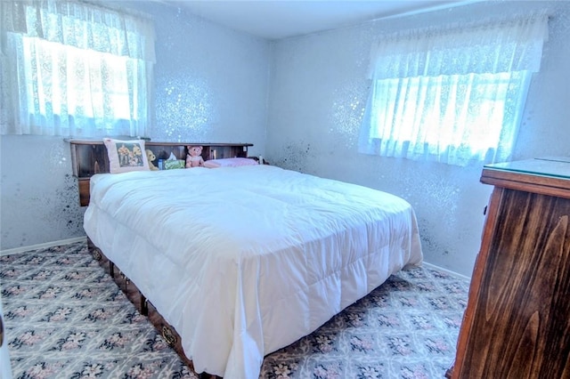 bedroom featuring baseboards and a textured wall