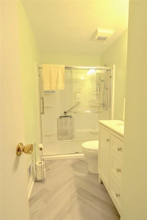 bathroom featuring vanity, toilet, and a stall shower