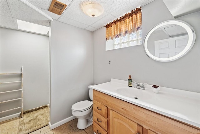 bathroom featuring tile patterned floors, visible vents, toilet, and a drop ceiling