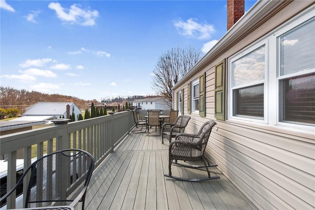 wooden deck with outdoor dining space and a residential view