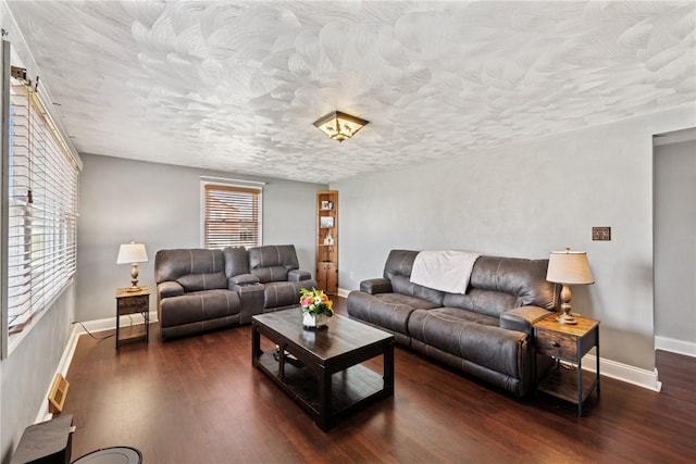 living area featuring wood finished floors, baseboards, and a textured ceiling