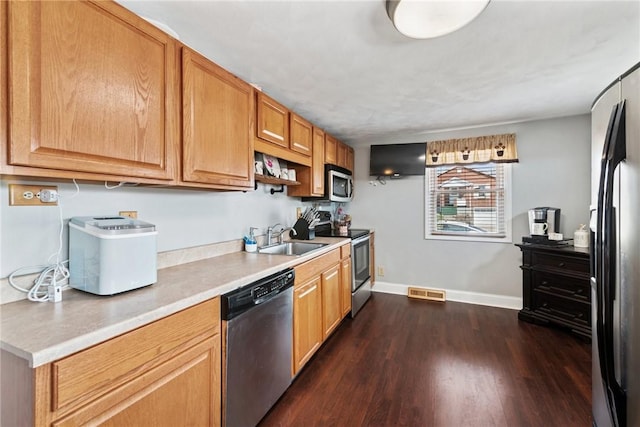 kitchen featuring visible vents, a sink, light countertops, appliances with stainless steel finishes, and dark wood-style flooring