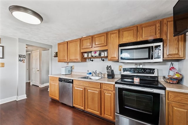 kitchen with a sink, stainless steel appliances, dark wood-style floors, and light countertops