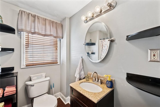 full bath with baseboards, toilet, and vanity