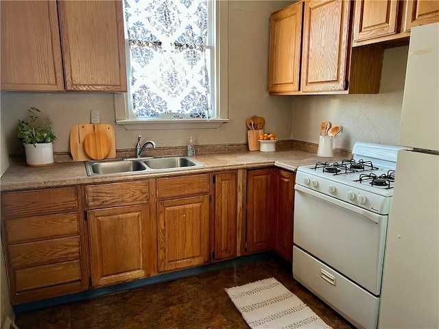 kitchen featuring brown cabinetry, white appliances, light countertops, and a sink