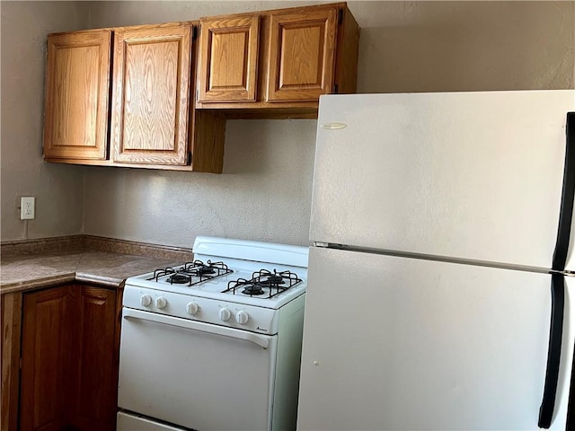 kitchen featuring white appliances and brown cabinets