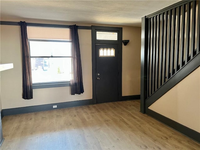 entrance foyer with wood finished floors, baseboards, and a textured ceiling