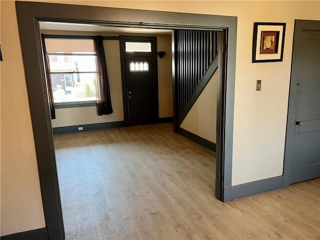 foyer entrance featuring baseboards and light wood-type flooring