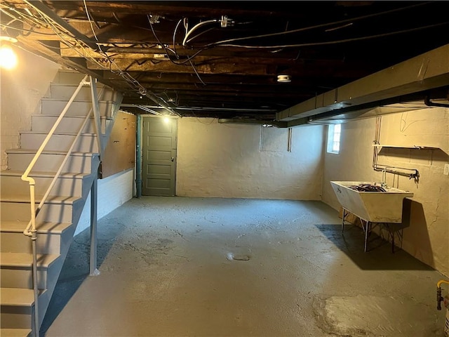 basement featuring stairs and a sink