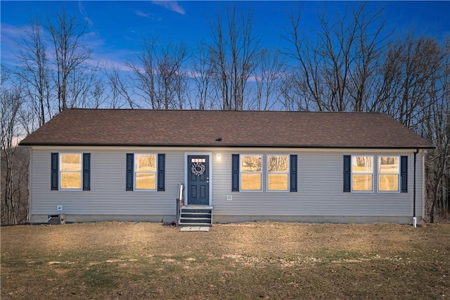 single story home featuring entry steps, a front yard, and a shingled roof
