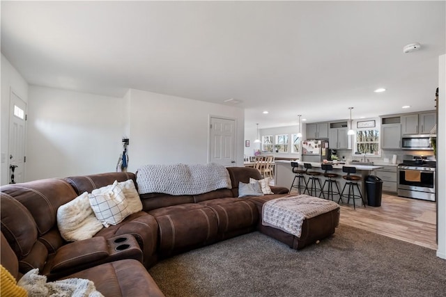 living area with recessed lighting and light wood-style floors