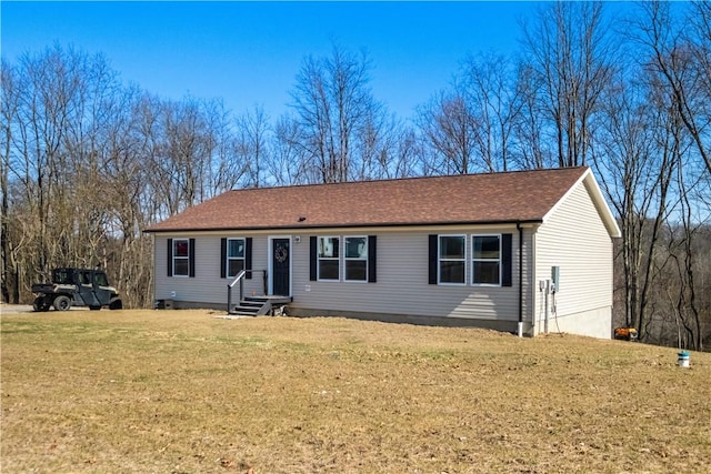 ranch-style home with roof with shingles, a front yard, and entry steps