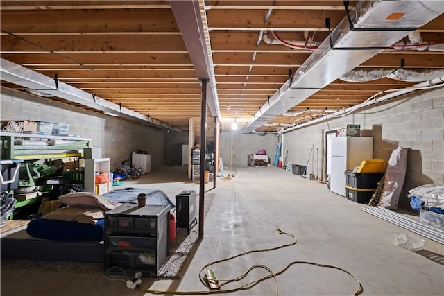 unfinished below grade area with freestanding refrigerator